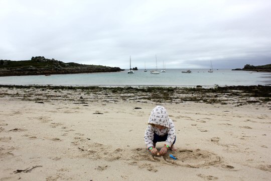My daughter looking for shells on the beach at St Agnes - my reasons to visit the Isles of Scilly