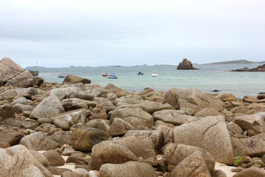View of the rocks on the beach at St Agnes in the Isles of Scilly with the sea in the distance