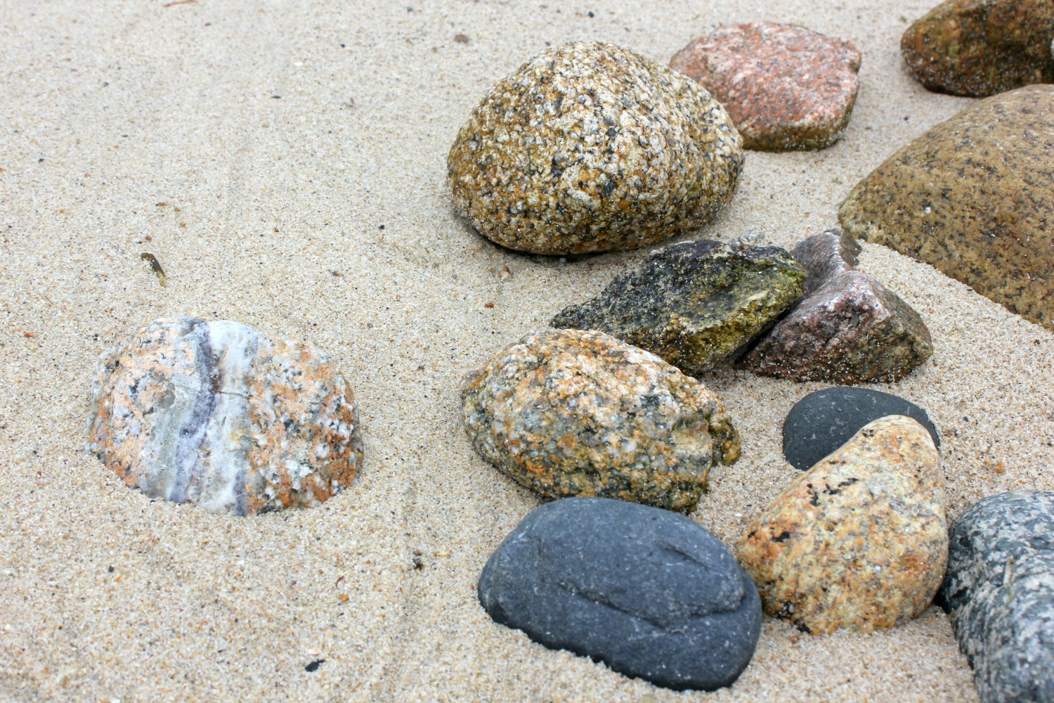 Multicoloured rocks on the sand - my reasons to visit the Isles of Scilly