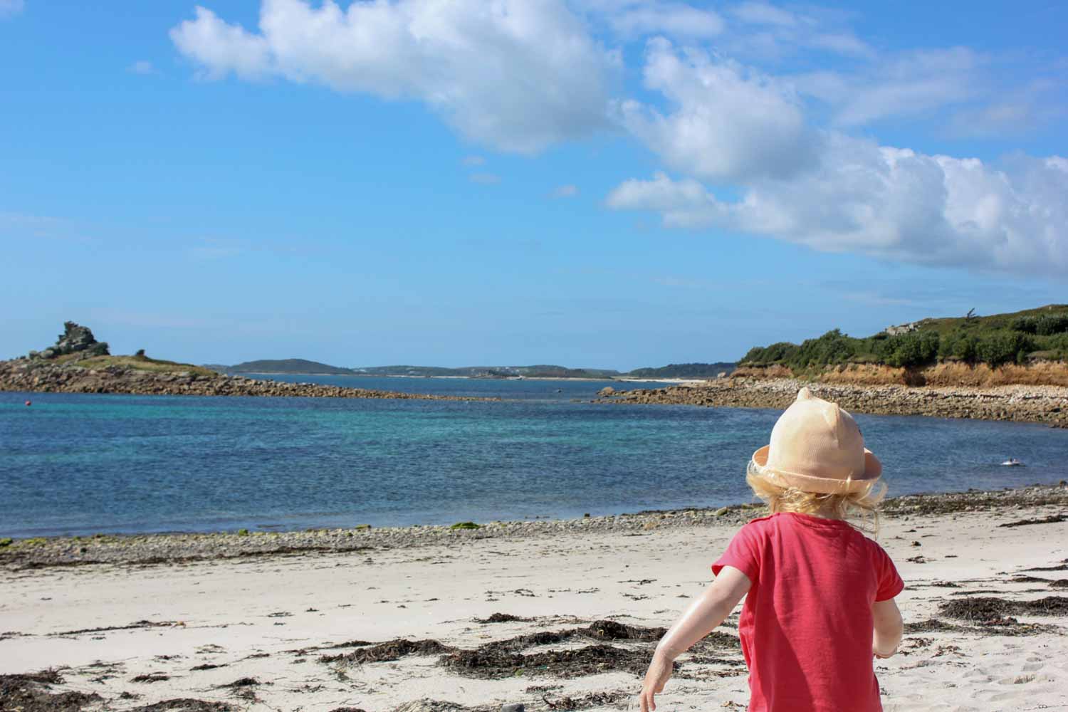 My daughter running down the beach to the sea in the Isles of Scilly - the beautiful beaches are one of many reasons to visit the Isles of Scilly