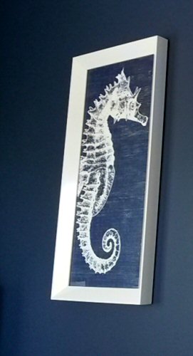 Framed white seahorse art against a dark blue wall in our Anna Maria Island holiday home