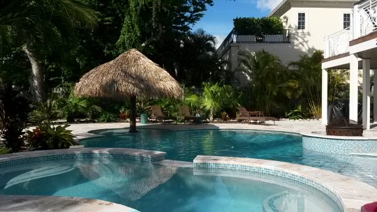 Pools and table with palapa at our Anna Maria Island holiday home