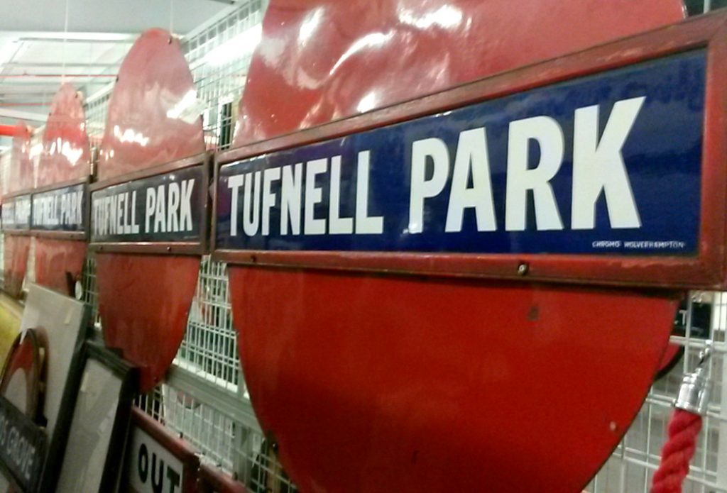 Vintage red and blue tube signs for various stations - exploring the London Transport Museum depot with kids
