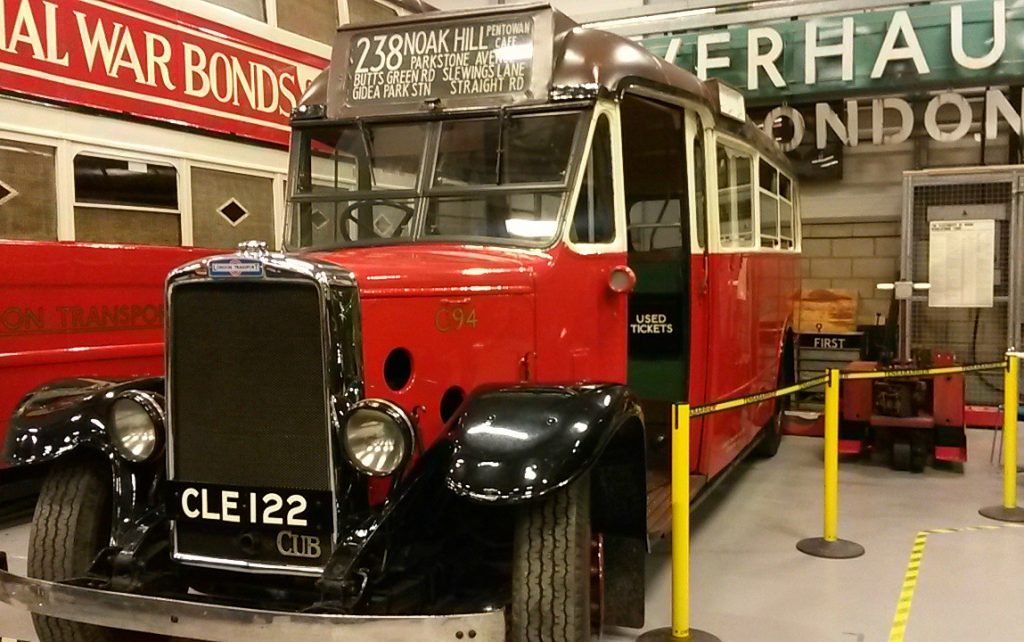 Vintage bus on display at the London Transport Museum depot with kids