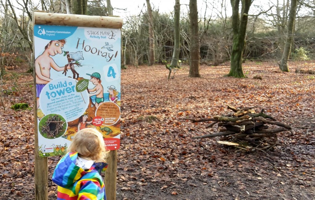 My daughter by one of the activity boards on the Stick Man trail at Wendover Woods in Buckinghamshire