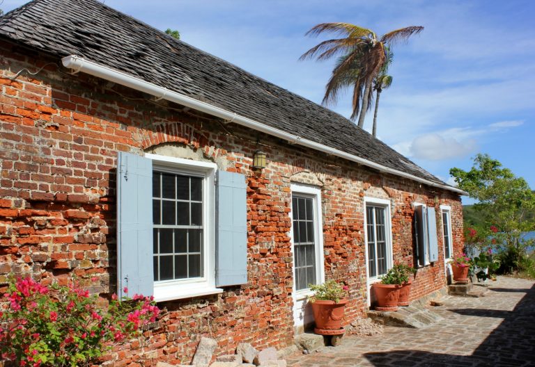 One of the historic buildings at Nelsons Dockyard Antigua - red bricks dating back centuries with a palm tree in the background