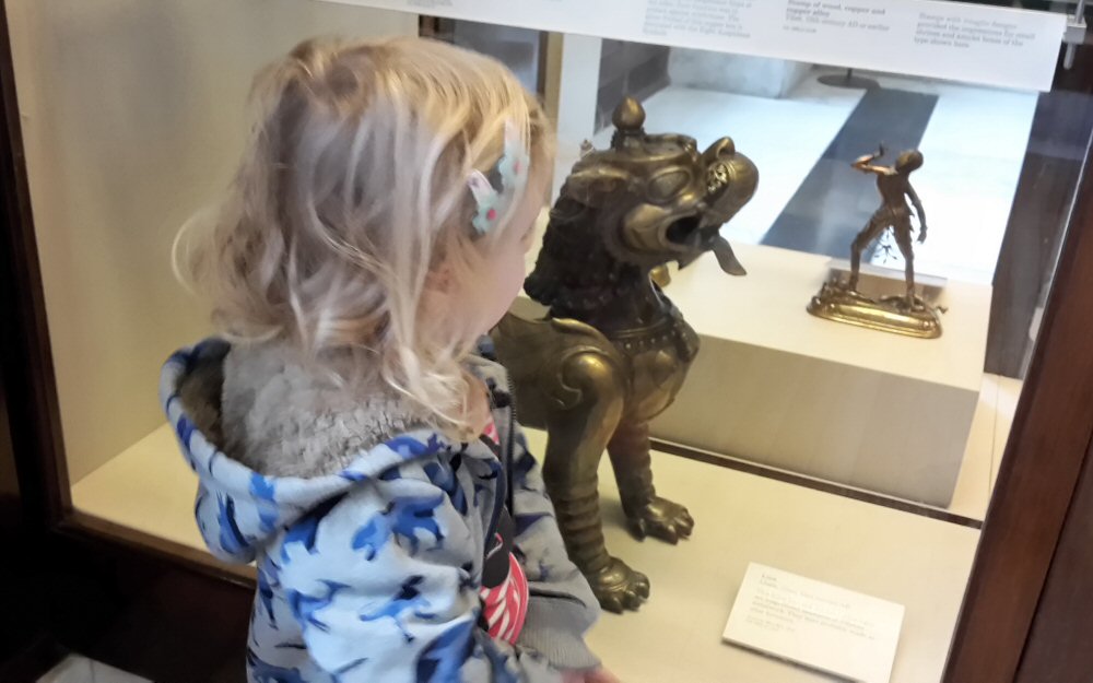 My daughter gazes into a display case in one of the Asia galleries as we followed the British Museum activity trail - visiting the British museum with kids