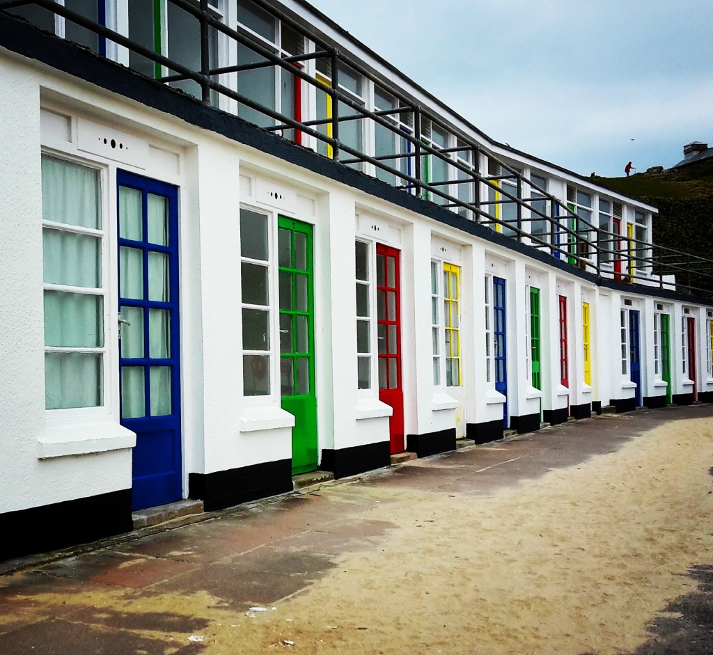 Brightly coloured doors of the beach huts at Porthgwidden beach, St Ives
