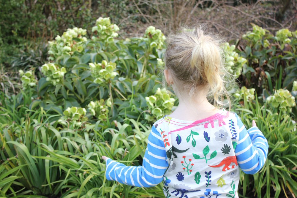 My daughter looks at the flowers in the gardens at Cliveden on the National Trust Easter Egg trail