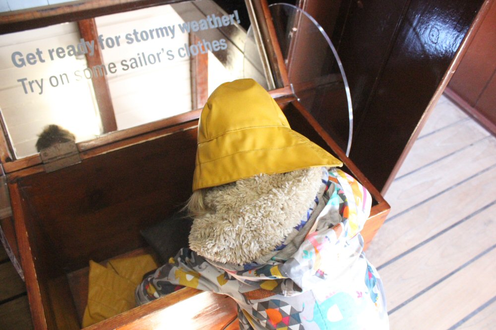 My daughter wearing a rainhat from the dressing up box - visiting the Cutty Sark with kids on a day out in Greenwich