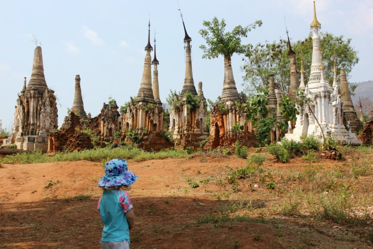A small girl looks at some of the stupas of In Dein, near Inle Lake in Burma - my guide to visiting Burma with kids