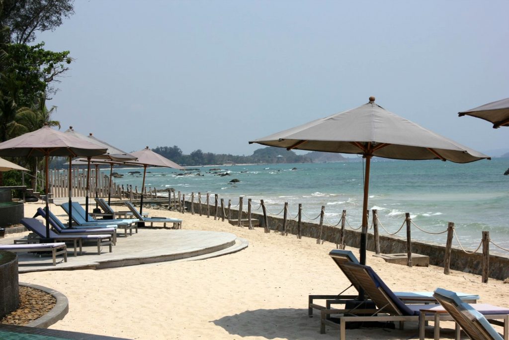 View onto the small section of beach at Hilton Ngpali Beach in Burma with beach umbrellas and loungers - our Burma beach holiday
