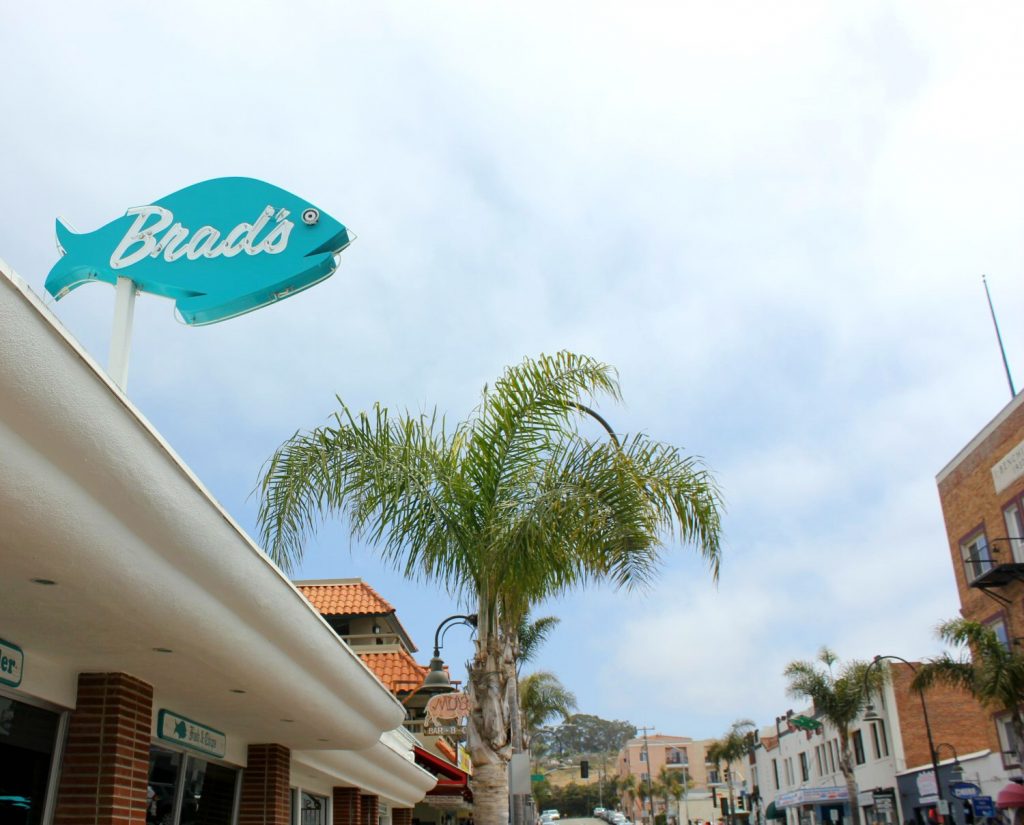 View of palm trees and turquoise restaurant sign at Pismo Beach - my Pacific Coast Highway pictures and reasons to visit California