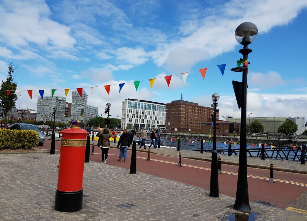 View of Albert Dock, Liverpool and red post box with flags above - exploring the Albert Docks kids' attractions.