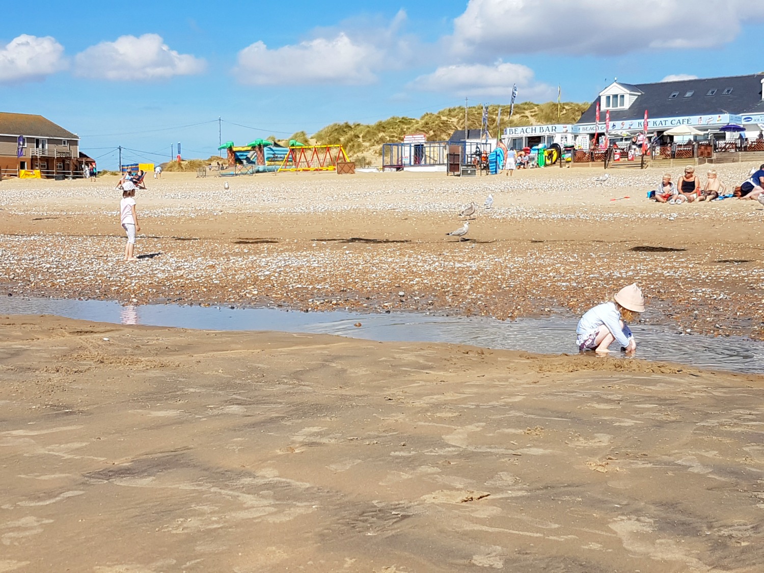 Girl playing in the water on Camber Sands beach in East Sussex - spending a weekend in East Sussex with kids before the start of school, to explore the history and coastline