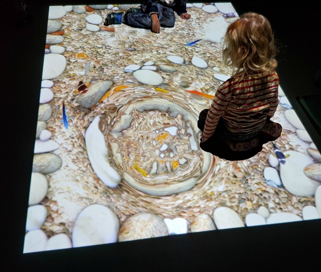 A girl on the responsive floor with its virtual fish - my 13 reasons to visit the National Marine Aquarium, Plymouth