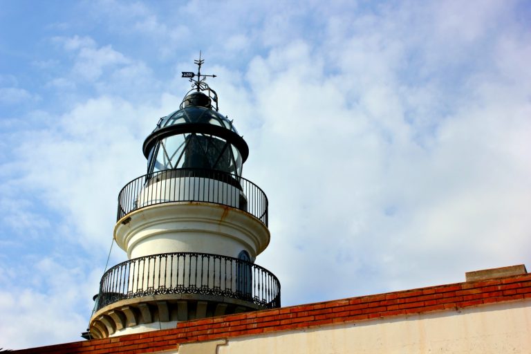 The lighthouse towers against a blue sky, the symbol of Calella - how to spend one day in Calella, Costa Barcelona, Spain