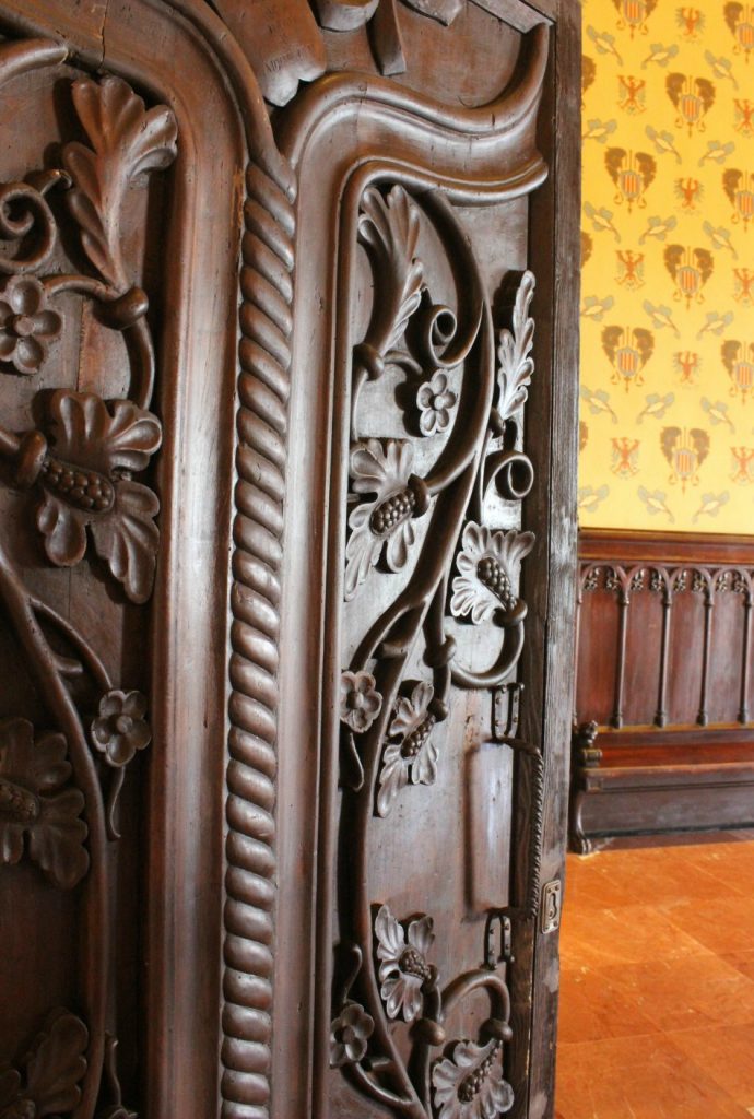 Intricately carved dark wooden door inside Castelldefels castle. My photo tour of Costa Barcelona