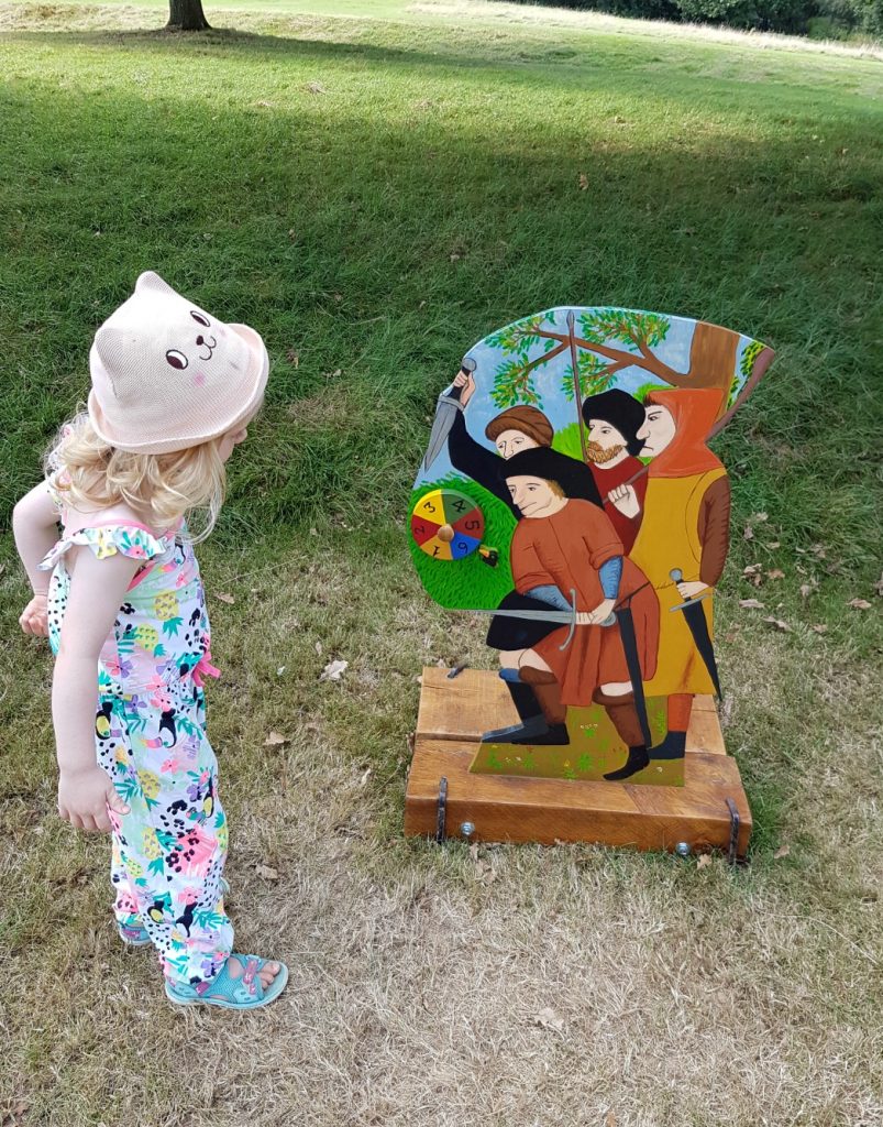 My daughter playing the medieval Game of Life at Bodiam Castle in East Sussex - my review and why it's great to visit Bodiam Castle with kids