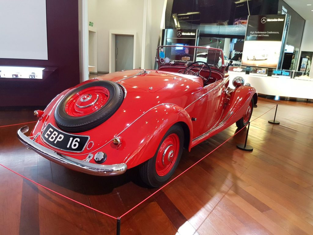 A vintage red Mercedes, one of the oldest cars in the mini museum at Mercedes Benz World - my review of our stay at Brooklands Hotel with kids