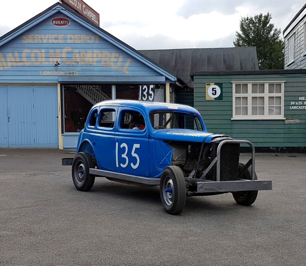 A vintage car drives past one of the old buildings at Brooklands Museum, Surrey - my review of Brooklands Museum, one of my top family days out in Surrey