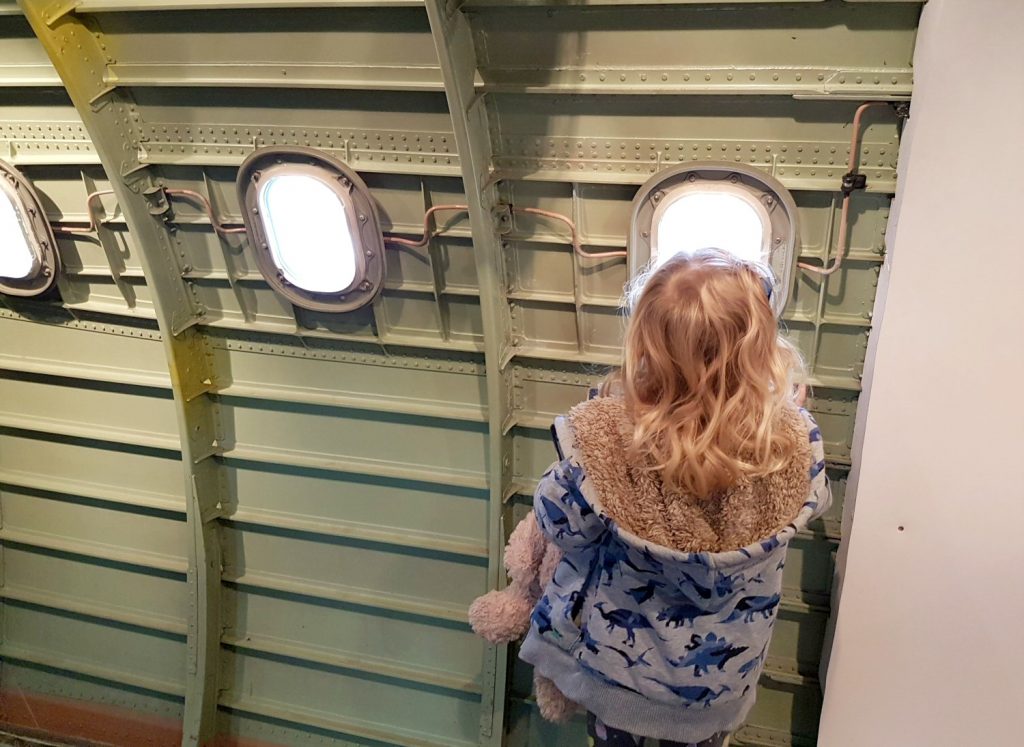 Girl looking out of the windows of Concorde - my review of Brooklands Museum in Surrey after our family day out