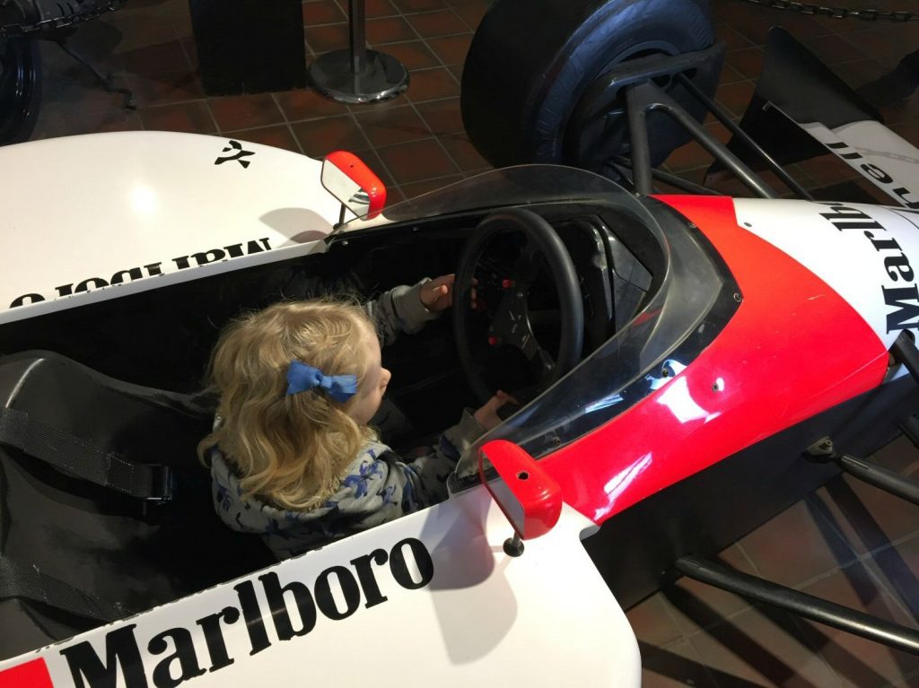 Girl in a racing car at Brooklands Museum, Surrey my review of Brooklands Museum, one of my top family days out in Surrey
