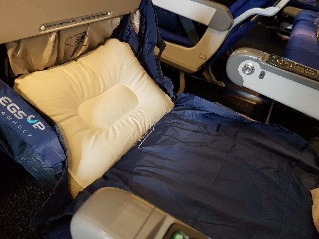Fly Legs Up Kids hammock attached to a tray table on a plane with inflatable cushion in, turning it into a bed - my Kids Fly Legs Up review