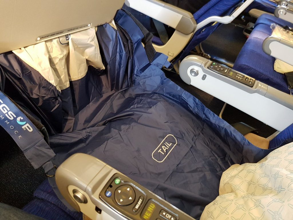 Fly Legs Up Kids hammock attached to a tray table on a plane, turning it into a bed - my Kids Fly Legs Up review