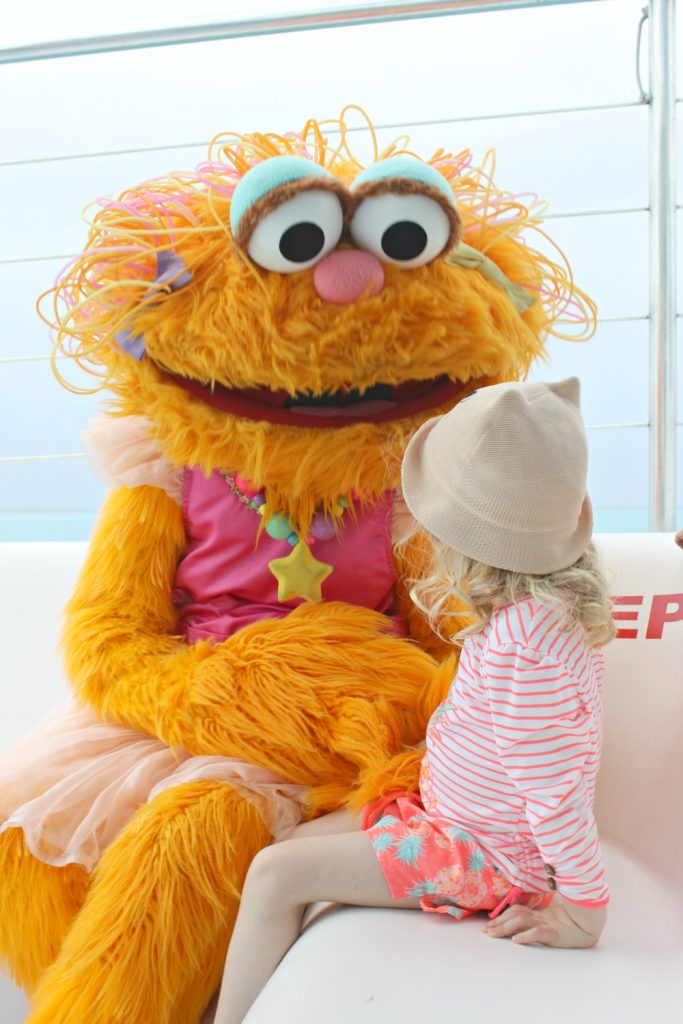 A girl meets Zoe from Sesame Street on a cruise at Beaches Resort in Providenciales- my Sunuva girls swimwear review