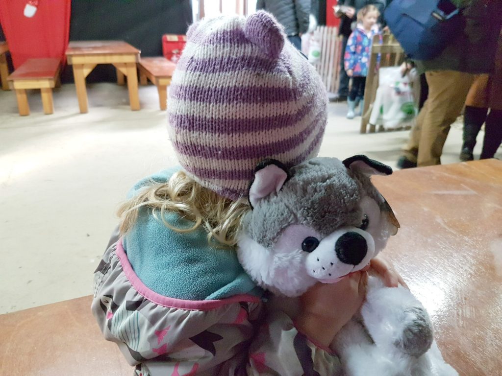 My daughter cuddling the finished husky at Willows Activity Farm Santa Spectacular near St Albans in Hertfordshire - my review of our family day out