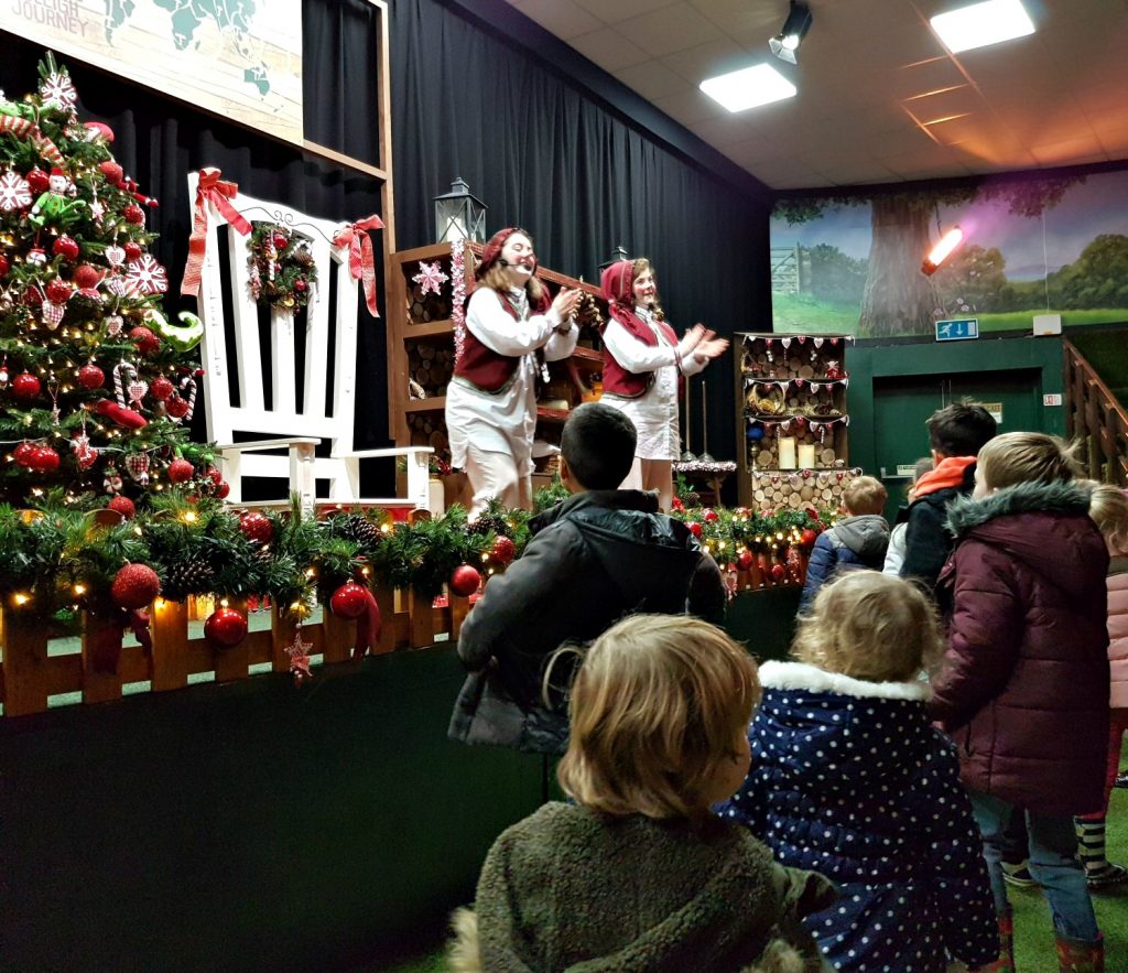 Children watching two elves called Berry and Twig lead elf school at Willows Activity Farm Santa Spectacular near St Albans in Hertfordshire - my review of our family day out