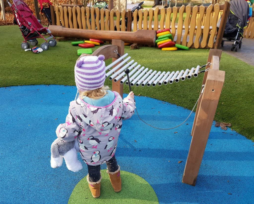 My daughter plays the musical instruments in Jeremy Fisher's musical pond in Peter Rabbit's adventure playground at Willows Activity Farm Santa Spectacular near St Albans in Hertfordshire - my review of our family day out