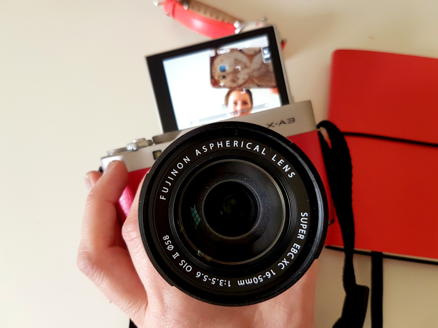 Shot of the flipped up selfie screen of the Fujifilm X-A3 mirrorless camera - sorting out the photos for my daughter's first baby passport