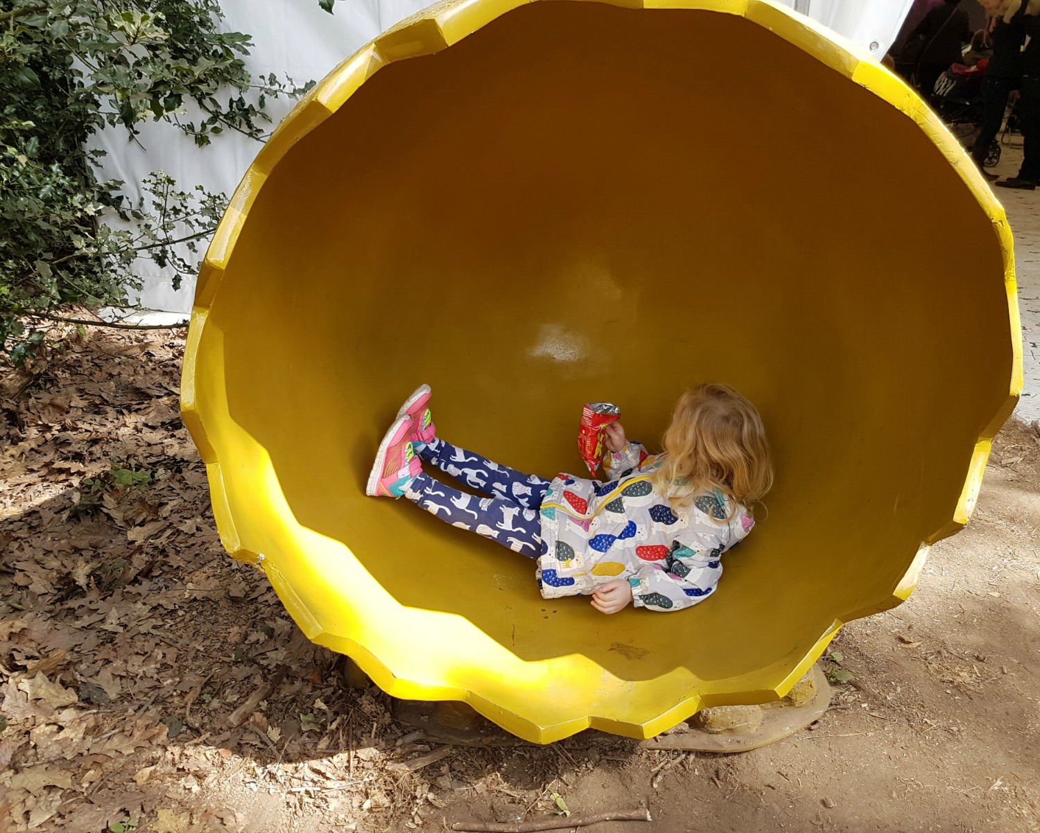 A girl sits in a dinosaur egg - discovering the Jurassic Kingdom dinosaurs in Osterley Park, London before their UK tour