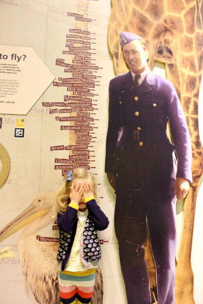 A girl measures herself against Roald Dahl and the quirky character height chart - my Roald Dahl Museum review