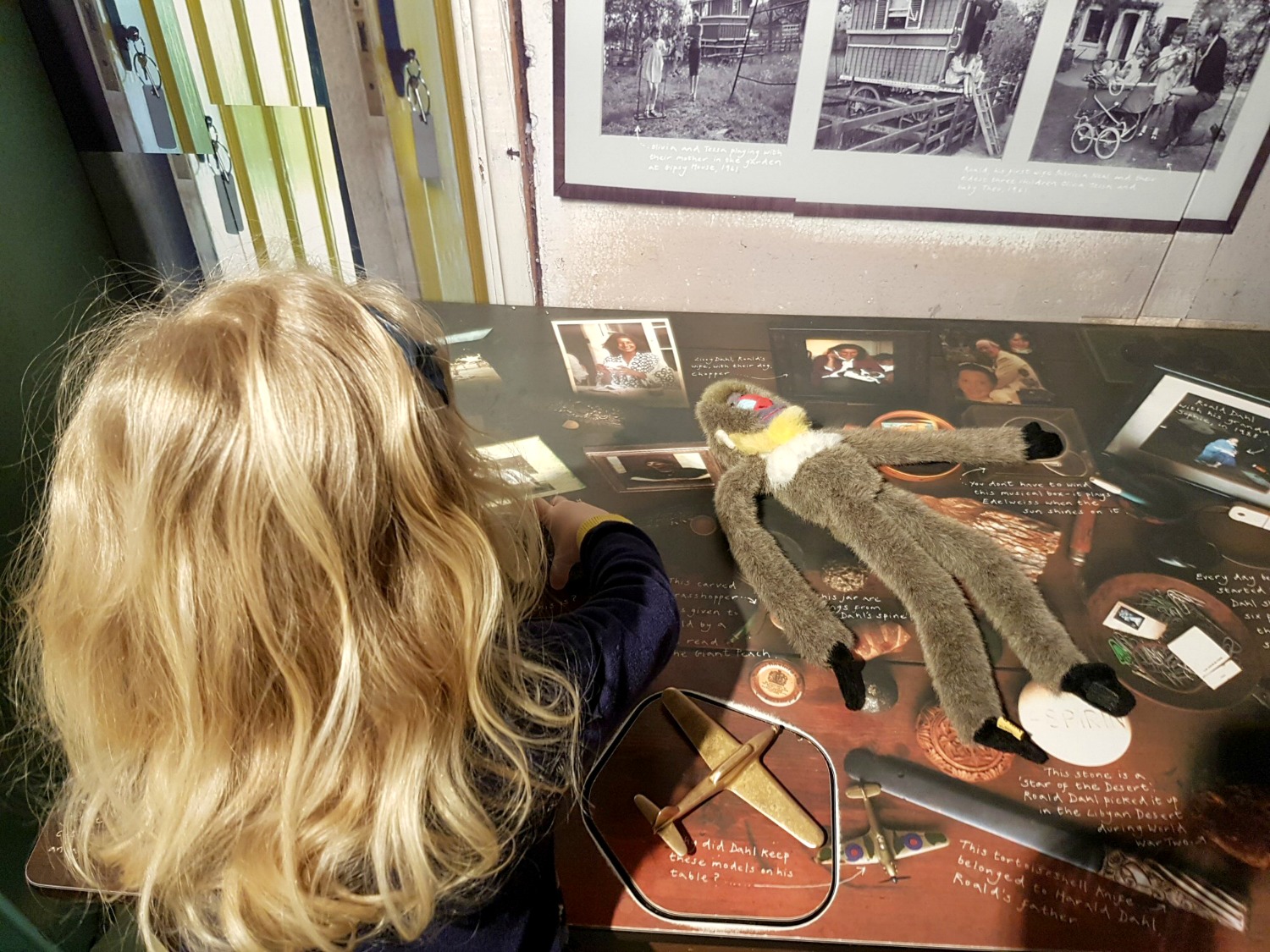 A girl and toy monkey looks at the odd items on a replica of Roald Dahl's desk - my Roald Dahl Museum review