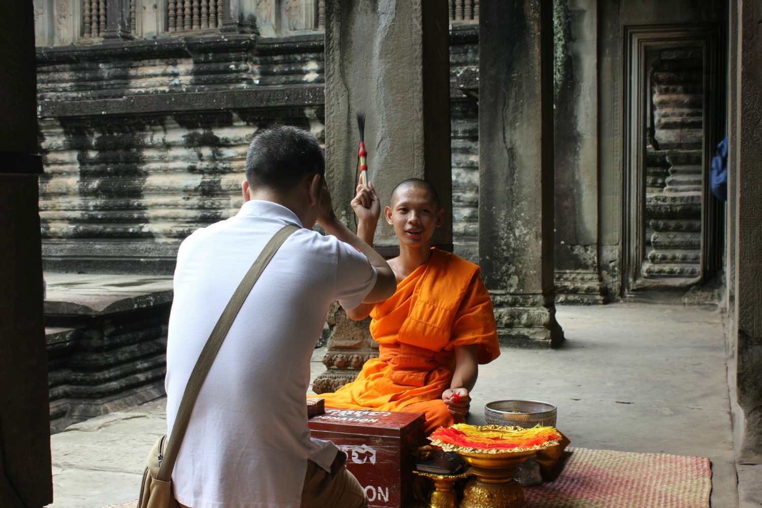 A monk blesses a man at Angkor Wat - visiting Angkor Wat with kids