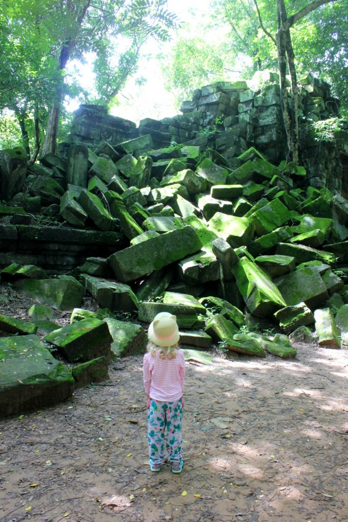 My daughter at the temple of Beng Melea in Cambodia, with some of the enormous collapsed stones - visiting the temples of Angkor with kids