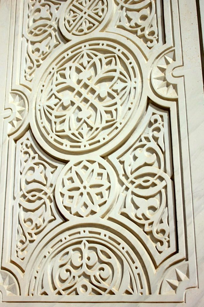 A view of some of the intricate geometric detailing on the white stone walls of the Sultan Qaboos Grand Mosque in Muscat Oman - the beautiful architecture is one of my nine reasons to visit Oman with kids