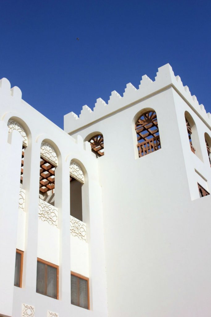 The white buildings of As Sifa marina against a blue sky, not far from Muscat, Oman - my nine reasons to visit Oman with kids