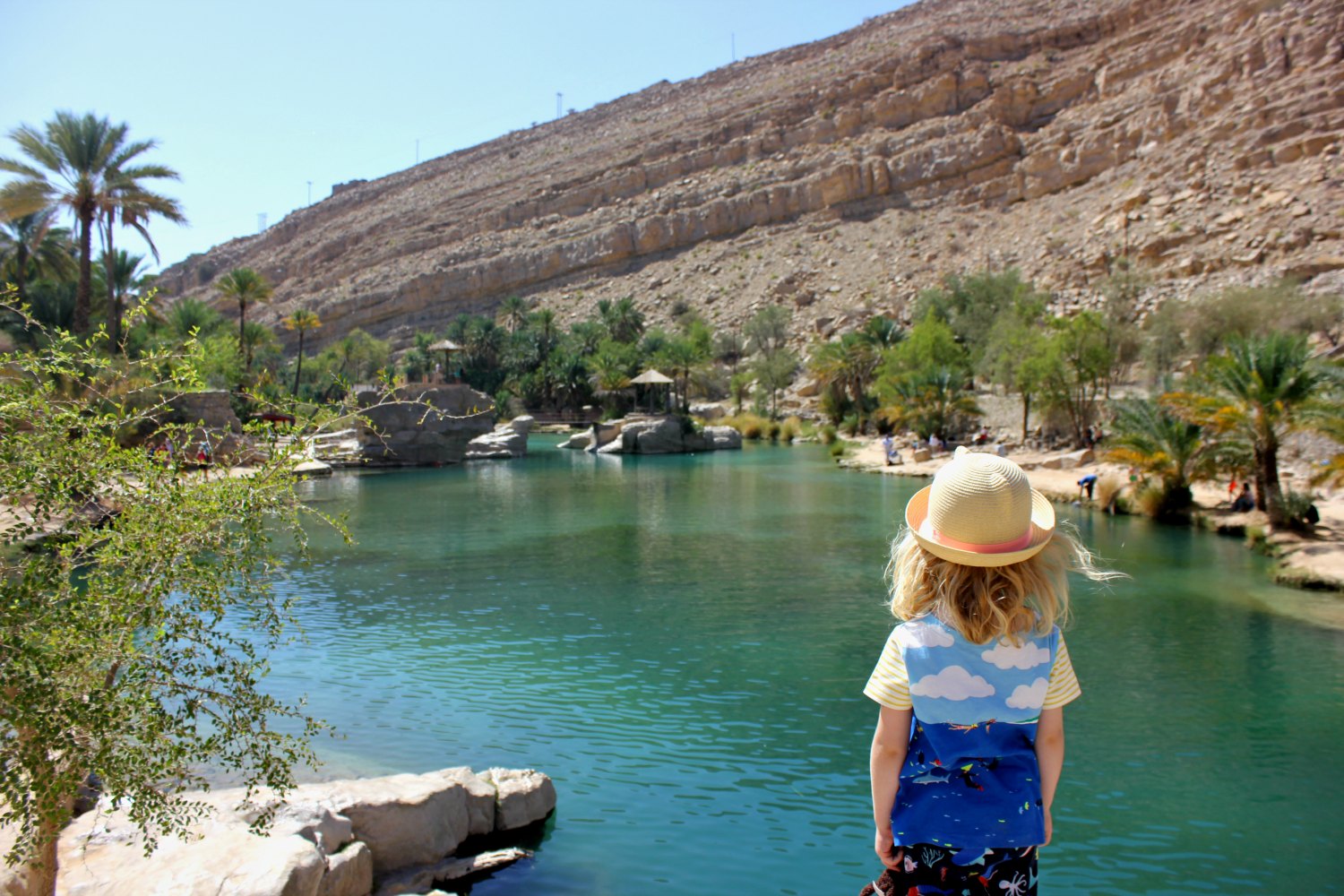My daughter looks out across the pool to the desert mountains at Wadi Bani Khalid - one of the surprised tucked away in the bone dry peaks, and one of my Oman travel lessons learned