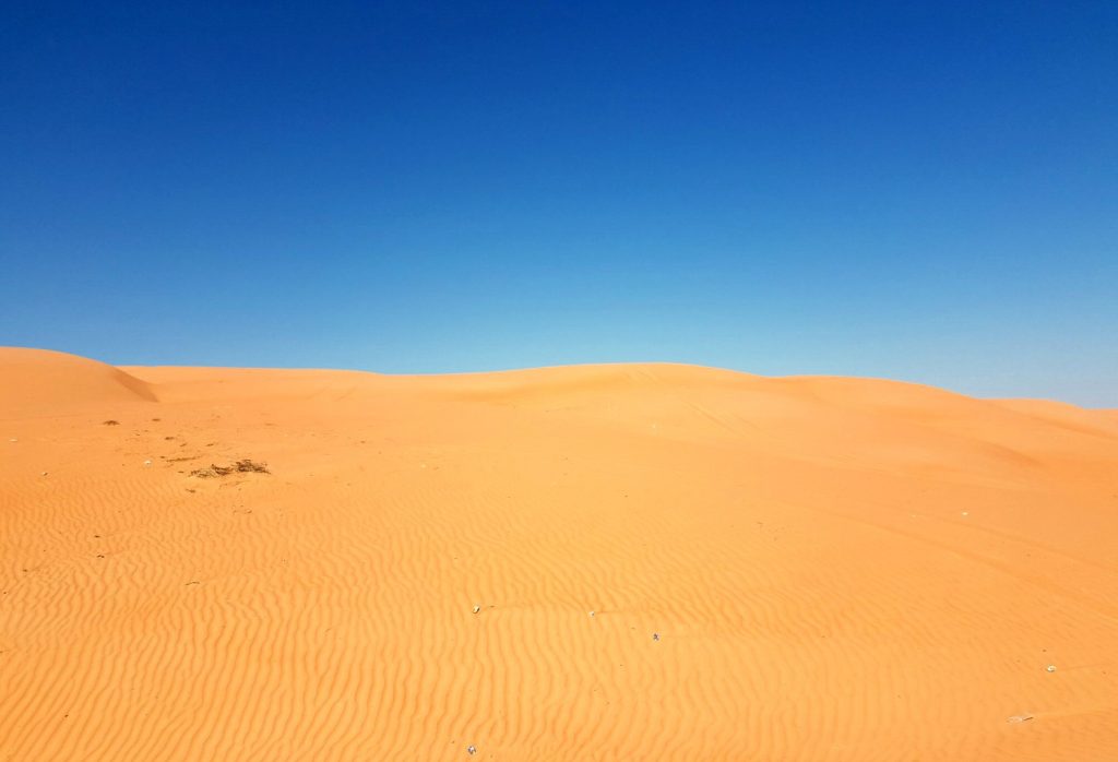 Bright orange sand against a bright blue sky at Wahiba Sands in Oman - my nine reasons to visit Oman with kids