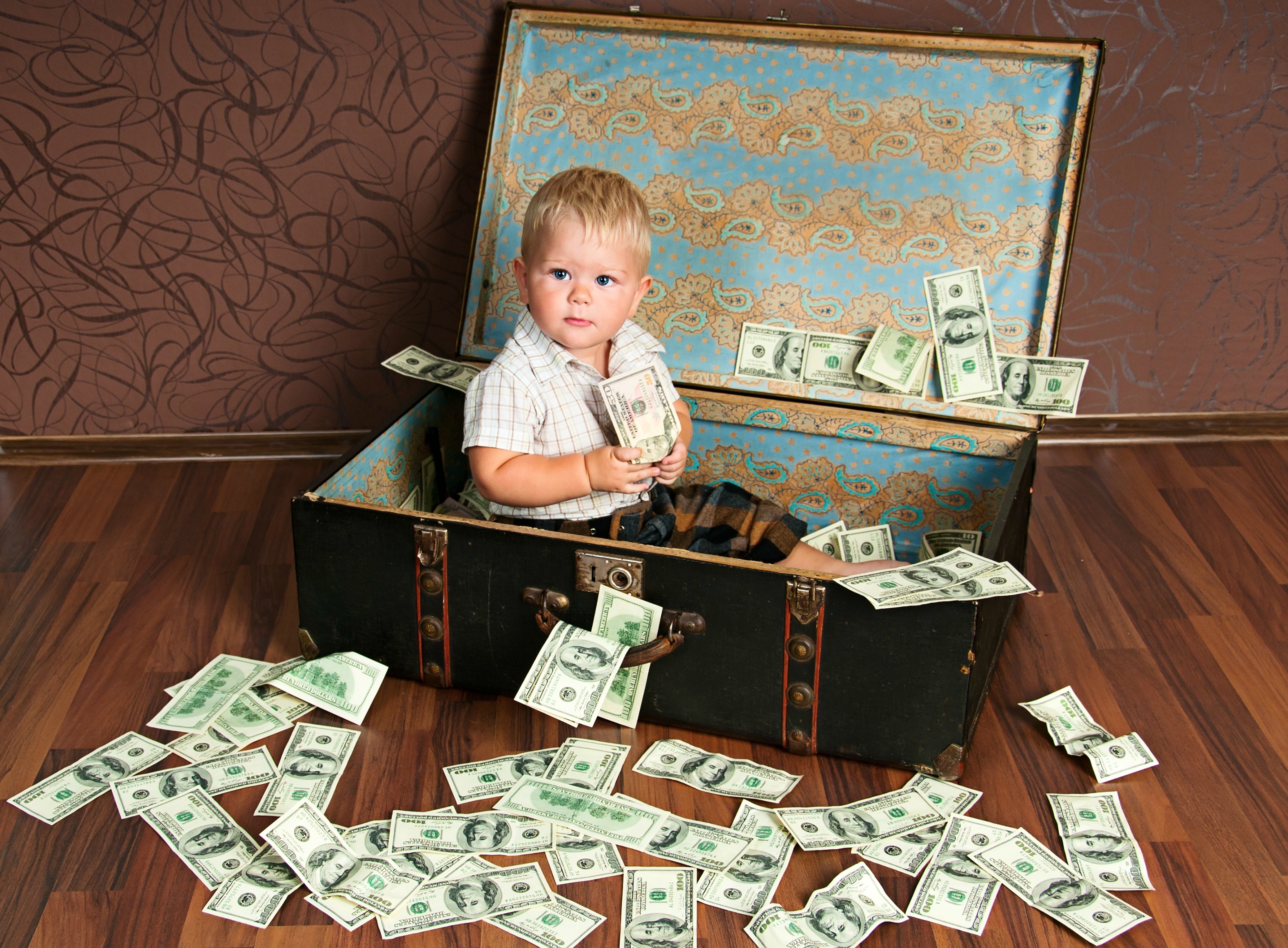 A little boy sits in a suitcase surrounded by money - if money were no object, these are the places on my lottery travel wishlist