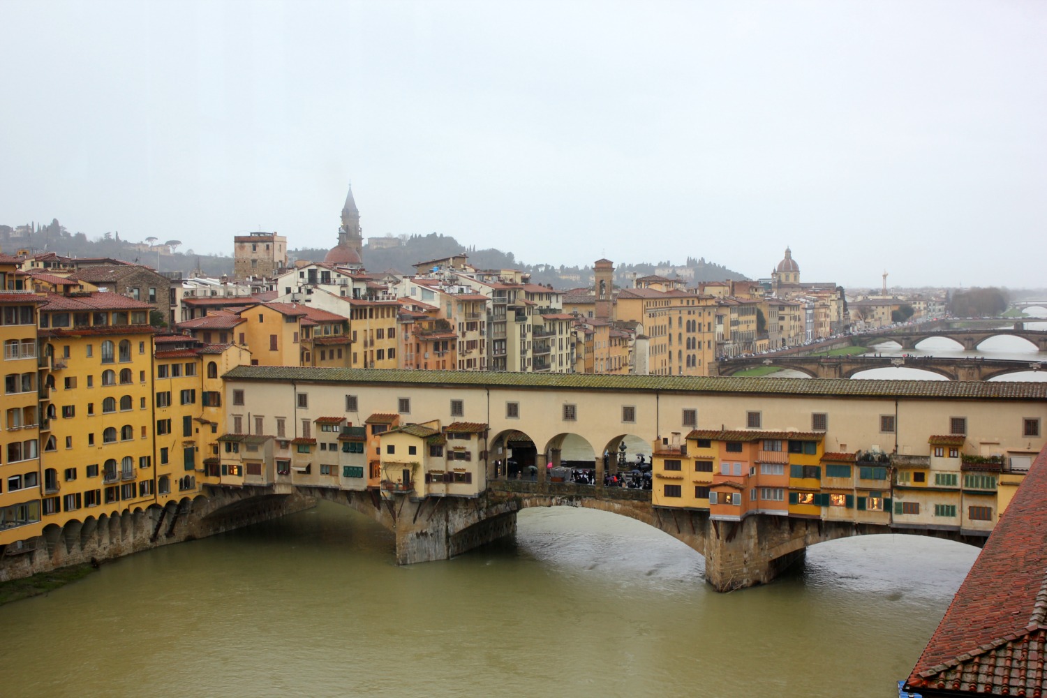A view over the river Arno in Florence, Italy, to the Ponte Vecchio and Vasari corridor - my Uffizi tour with kids and gelato making day in Florence