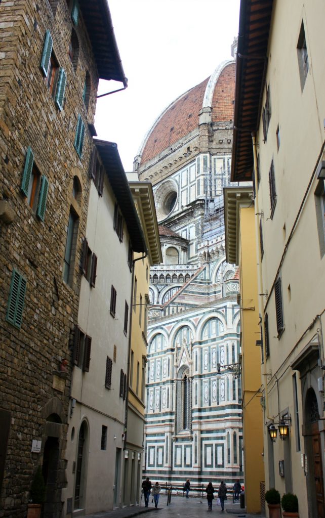A view of the Duomo through an alleyway in Florence, Italy - my Uffizi tour with kids and gelato making day in Florence