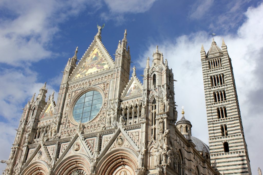 The facade of the Duomo and the cathedral belltower One of the shields and emblems showing the animals and symbols representing Siena's 17 areas or contrada - exploring Siena with kids, our tour discovering art, history and animals