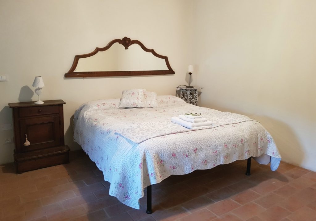 The double bed with mirror headboard in our bedroom at Villa Le Capanne near Volterra in Tuscany - my review of the perfect big family villa in Tuscany, Italy