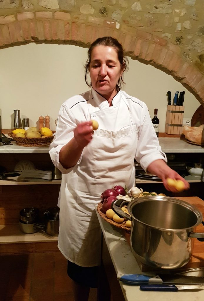 Fabiola Giovannini, one of the owners, preparing dinner in the kitchen at Villa Le Capanne near Volterra in Tuscany - my review of the perfect big family villa in Tuscany, Italy