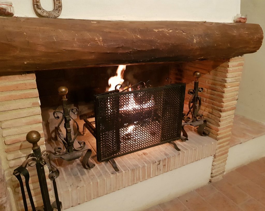 Wood fire burning in the dining room at Villa Le Capanne near Volterra in Tuscany - my review of the perfect big family villa in Tuscany, Italy